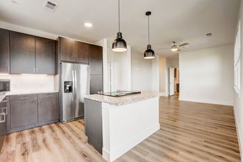 A kitchen with a white island and dark brown cabinets. at Aurora Watson Branch, Texas
